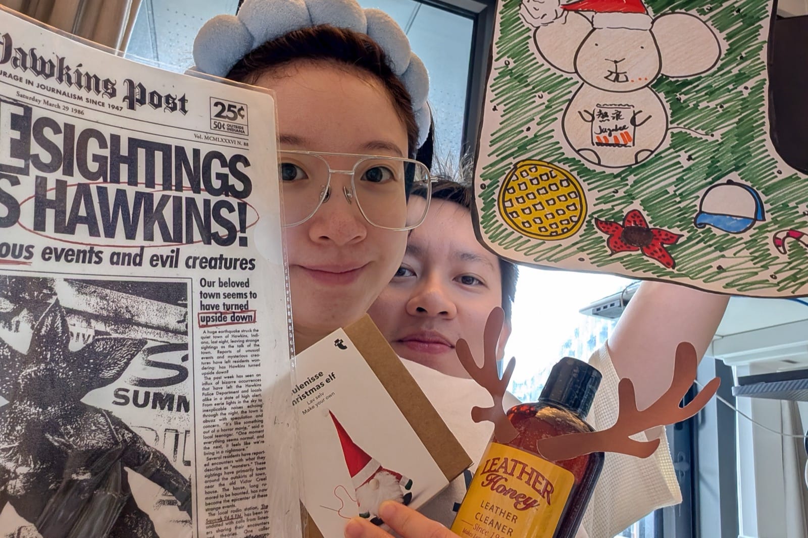 Flora and Hanny crowded into a selfie at home, holding up gifts on a holiday morning.